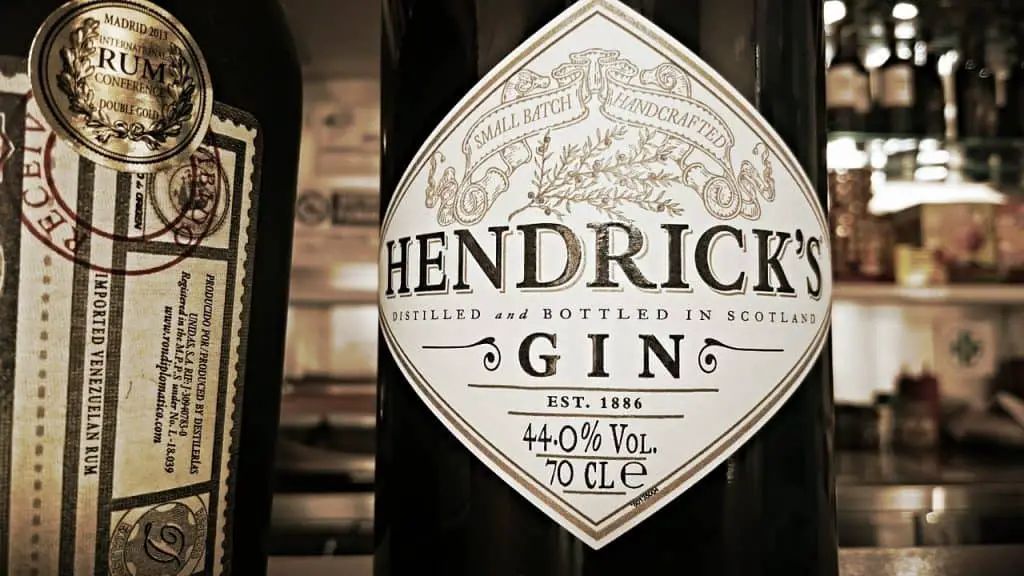 Up close view of a bottle of Hendrick's gin. The bottle is a light black and the label is white. 