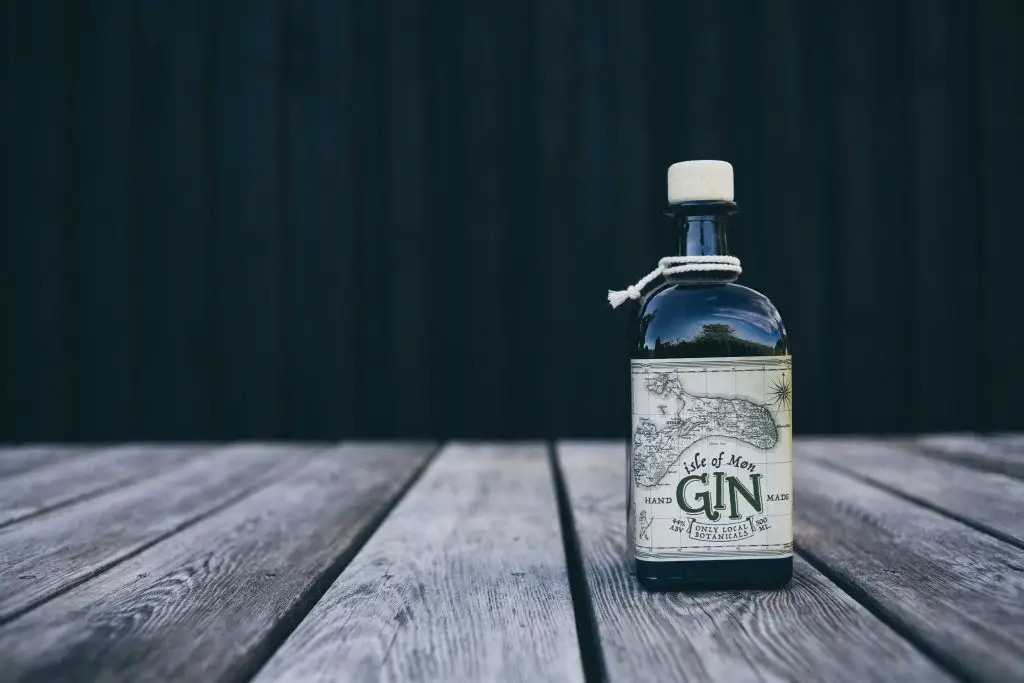 A bottle of Isle of Møn Gin on a wooden floor.