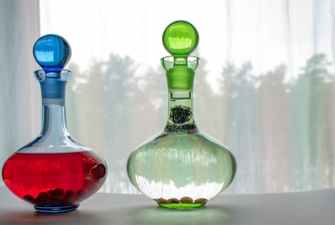 Two beautiful decanters with gin and fruits inside.