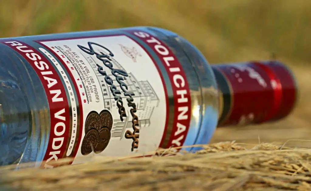 An up close view of a Stolichnaya vodka on the ground.